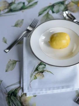 Beautiful table setting - printed tablecloth, plate, yellow lemons Stock Photos