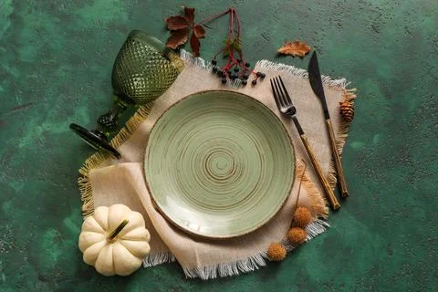 Beautiful table setting with pumpkin and berries on green background Stock Photos