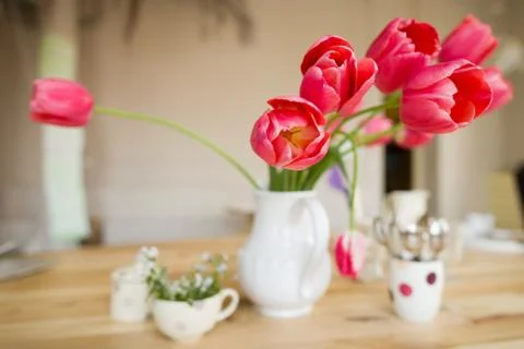 Beautiful table setting with red tulips, forget-me-not and cups on the wooden Stock Photos