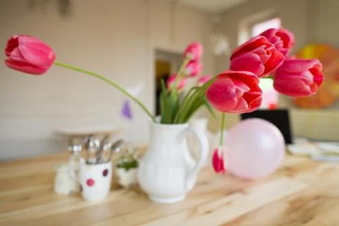 Beautiful table setting with red tulips, forget me not and cups on the table Stock Photos