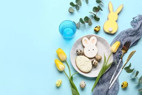 Beautiful table setting with sweet cookies, Easter eggs, tulip flowers and eu Stock Photos