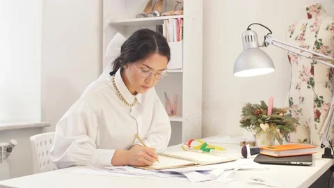 Beautiful tailor designer writing in notebook Stock Footage 122762410