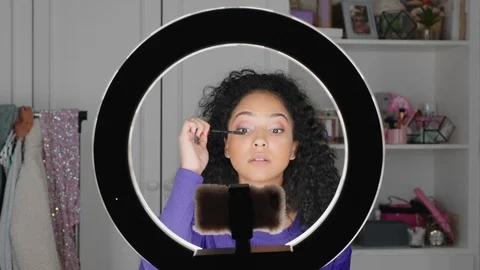 Beautiful teenage girl vlogger filming makeup tutorial sharing beauty video Stock Footage