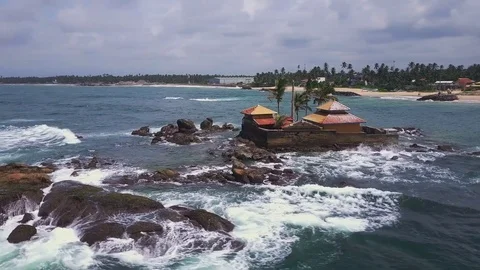 Beautiful temple on rocks in ocean sunset drone footage Video stock 84711296