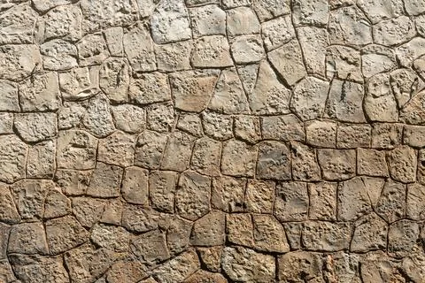 A beautiful texture of an old wall from gray and orange stones with cracks Stock Photos