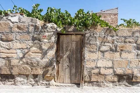 A Beautiful texture of an old wall from orange stones with brown door and gre Stock Photos