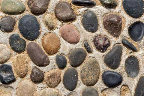 Beautiful texture of path of gray and color smooth stones on the yellow backg Stock Photos