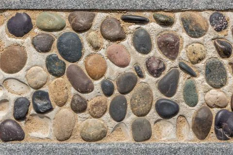Beautiful texture of path of gray and color smooth stones on the yellow backg Stock Photos