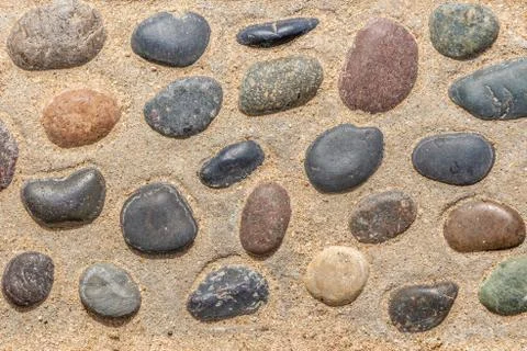 Beautiful texture of path of gray and color smooth stones on the yellow backg 스톡 사진