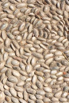 A Beautiful texture of path of gray and white smooth stones on the yellow bac Stock Photos