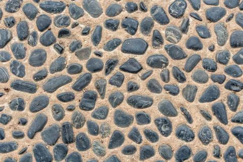 Beautiful texture of path of gray smooth stones on the orange background is i Stock Photos