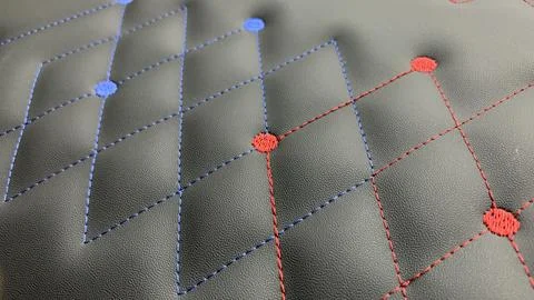 Beautiful thread stitching and embroidery blue and red on the black leather Stock Photos