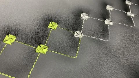 Beautiful thread stitching and embroidery yellow and white on the black lea.. Stock Photos