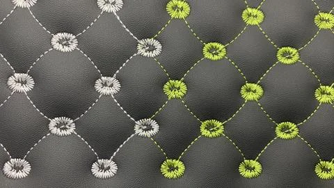 Beautiful thread stitching and embroidery on the black leather. Stock Photos