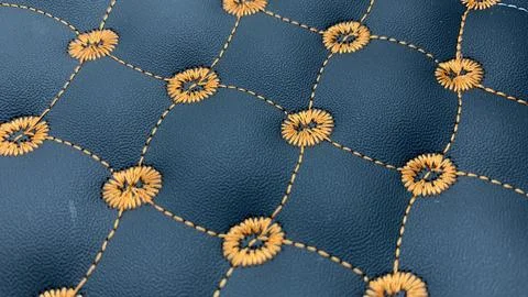 Beautiful thread stitching and embroidery on the blue leather. Stock Photos