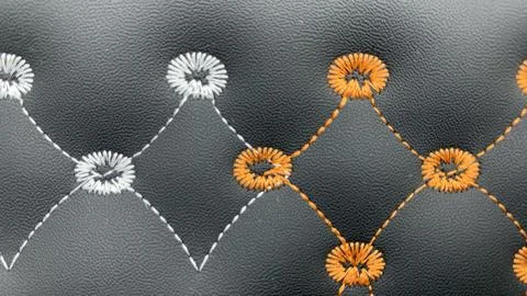 Beautiful thread stitching and embroidery on the black leather. Stock Photos