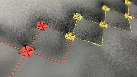 Beautiful thread stitching and embroidery on the black leather. Stock Photos