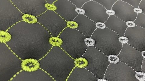Beautiful thread stitching and embroidery on the black leather. Stock Photos