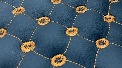 Beautiful thread stitching and embroidery on the blue leather. Stock Photos
