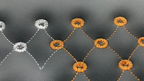 Beautiful thread stitching and embroidery on the black leather Stock Photos
