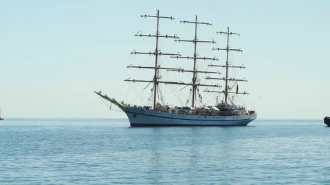 A beautiful three-sailing ship is sailing to the port 4k Stock Footage 113880371