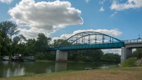 Beautiful time lapse of clouds above bridge on the river with traffic. Stock Footage 115473214