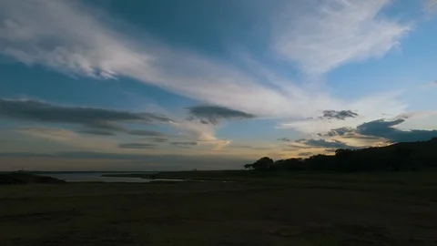 Beautiful Time-lapse of clouds above lake and shore Stock Footage 126988636