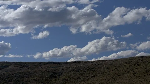 Beautiful time-lapse of clouds in blue sky along desert ridge in southwest U.S. Stock Footage 126925734