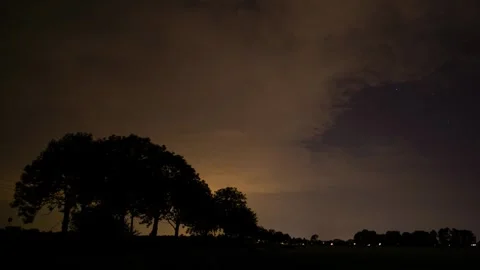 Beautiful time lapse of clouds passing behind the silhouette of trees at Stock Footage 282258899