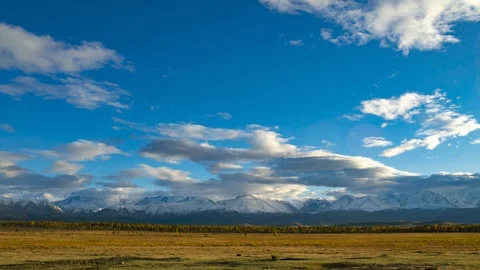 Beautiful timelapse. Clouds float above snow-capped mountain peaks. The setting Stock Footage 102498640
