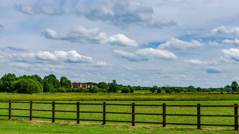 Beautiful timelapse with fast transforming clouds over a green field Stock Footage 115271395