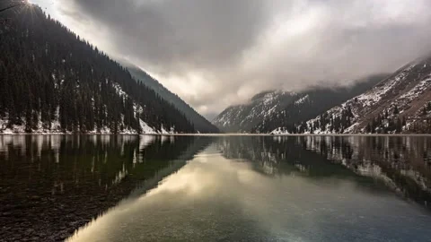 Beautiful timelapse of mountain lake with clouds and snow. Stock-Footage 234846266