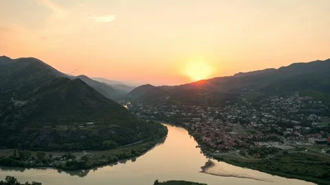 Beautiful timelapse of sun setting over mountains behind the old Georgian town Stock Footage 106576605