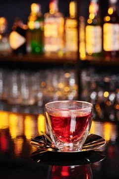 Beautiful transparent cup with red fruit tea on a shiny dark table on a blurred Stock Photos