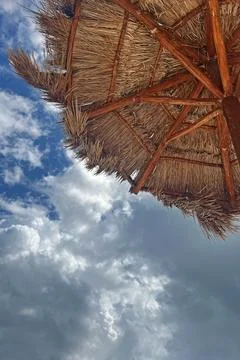 Beautiful tropical island scene under a thatched umbrella with a dramatic s.. 스톡 사진