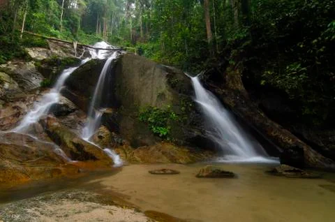 Beautiful tropical waterfall in lush surrounded by green forest.wet rock and  Stock Photos