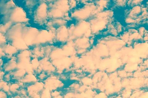 Beautiful unusual sky texture. small clouds tinted in pink color. Stock Photos