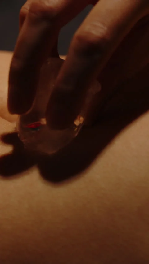 Beautiful vertical close up of an ice cube rubbing the body of an attractive Video stock 329212012