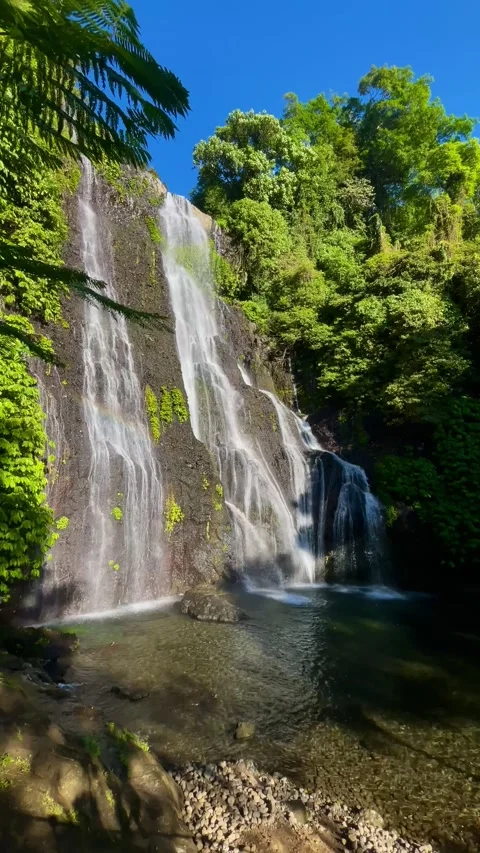 Beautiful vertical shot of twin waterfall with rainbow in Bali Stock Footage 336473783