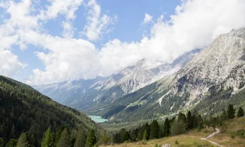 Beautiful view of alpine mountain range, valley and lake, Italy. Stock Photos