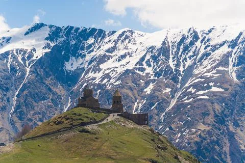 Beautiful view of ancient Gergeti Trinity Church in Kazbegi, Georgia. snow Stock Photos