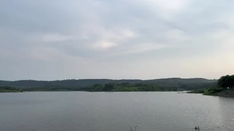 Beautiful view of artificial lake in the middle of green rice fields and hills Video stock 307613500