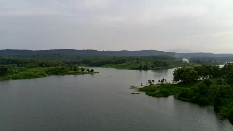 Beautiful view of artificial lake in the middle of green rice fields and hills Video stock 307625825