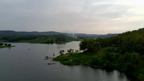 Beautiful view of artificial lake in the middle of green rice fields and hills Stock Footage 307625831