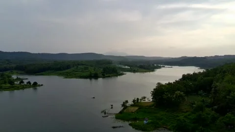 Beautiful view of artificial lake in the middle of green rice fields and hills Video stock 307625950