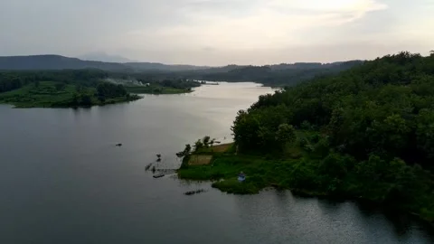 Beautiful view of artificial lake in the middle of green rice fields and hills Stock Footage 307625960