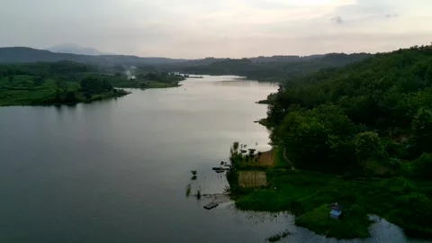 Beautiful view of artificial lake in the middle of green rice fields and hills Stock Footage 307626145