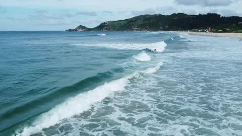Beautiful view of the beach with waves and surfers on a clear day Stock Footage 271557528