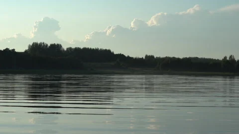 Beautiful view on blue lake surface with ripples, forest on bank and sky Video stock 138196661