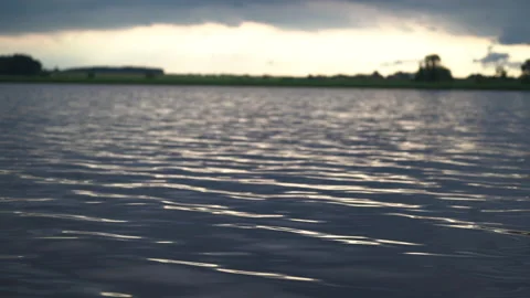 Beautiful view on blue lake surface with ripples, forest on bank and sky Vidéo 155710557